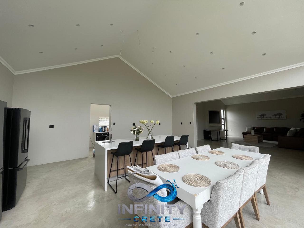 After — seamless light screed flooring across living, dining and kitchen, installed by Infinity Crete in Gauteng